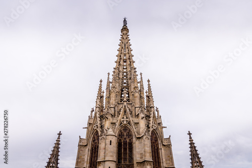 Photography The Cathedral of Barcelona, detail of the main spire in typical gothic style with stone friezes and gargoyles