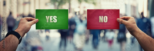 Фотография Man hands holding two different colored paper sheets with yes and no answers