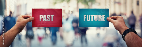Men hands holding two different colored paper sheets showing past and future directions over a crowded street background. Life dilemma, lost in time.