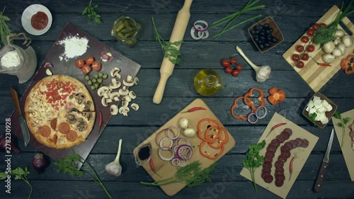 Wallpaper Mural Pizza on ecological black background.  Pizza with different filling: ham, salami, mushrooms, tomatoes, different cheese. There are also many other products on table for cooking and eating pizza. Torontodigital.ca