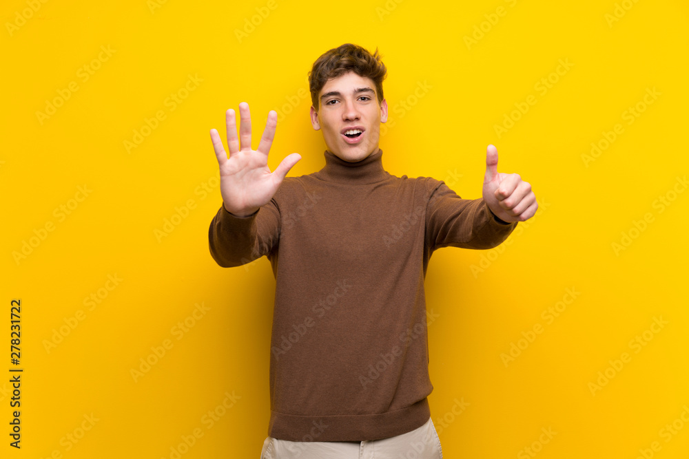 Handsome young man over isolated yellow background counting six with fingers Handsome young man over isolated yellow background counting six with fingers