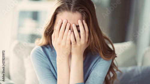 Sad young woman covered her face with her hands