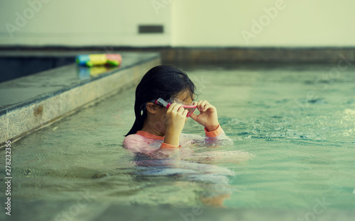 Girl plays water alone with goggles in summer time vacation