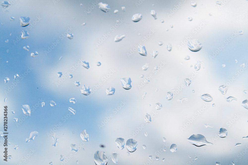 water drops (rain) on glass against a cloudy sky