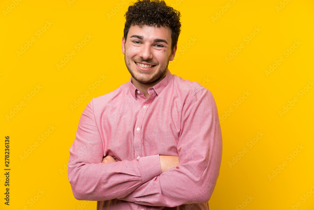 Man with curly hair over isolated yellow wall laughing Man with curly hair over isolated yellow wall laughing