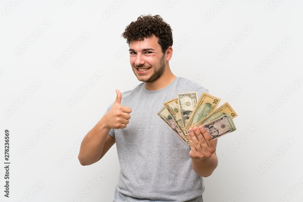 Man with curly hair over isolated wall taking a lot of money Man with curly hair over isolated wall taking a lot of money