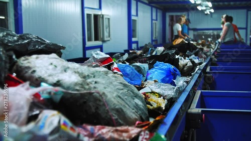 Workers at conveyor sorting garbage at a recycling plant. 4K (UHD)