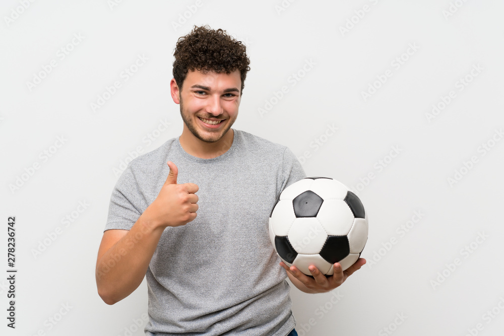 Man with curly hair over isolated wall holding a soccer ball Man with curly hair over isolated wall holding a soccer ball