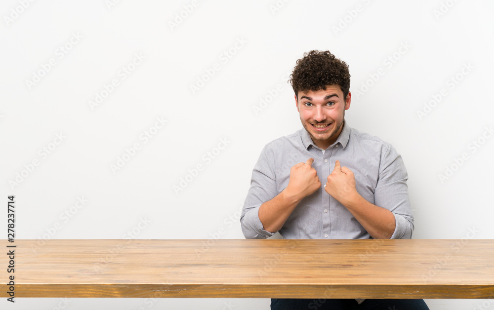Young man with a table with surprise facial expression Young man with a table with surprise facial expression