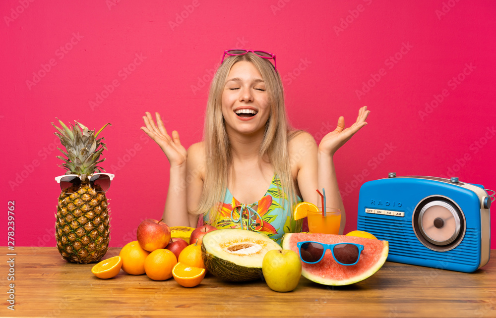 Young blonde woman with lots of fruits laughing Young blonde woman with lots of fruits laughing