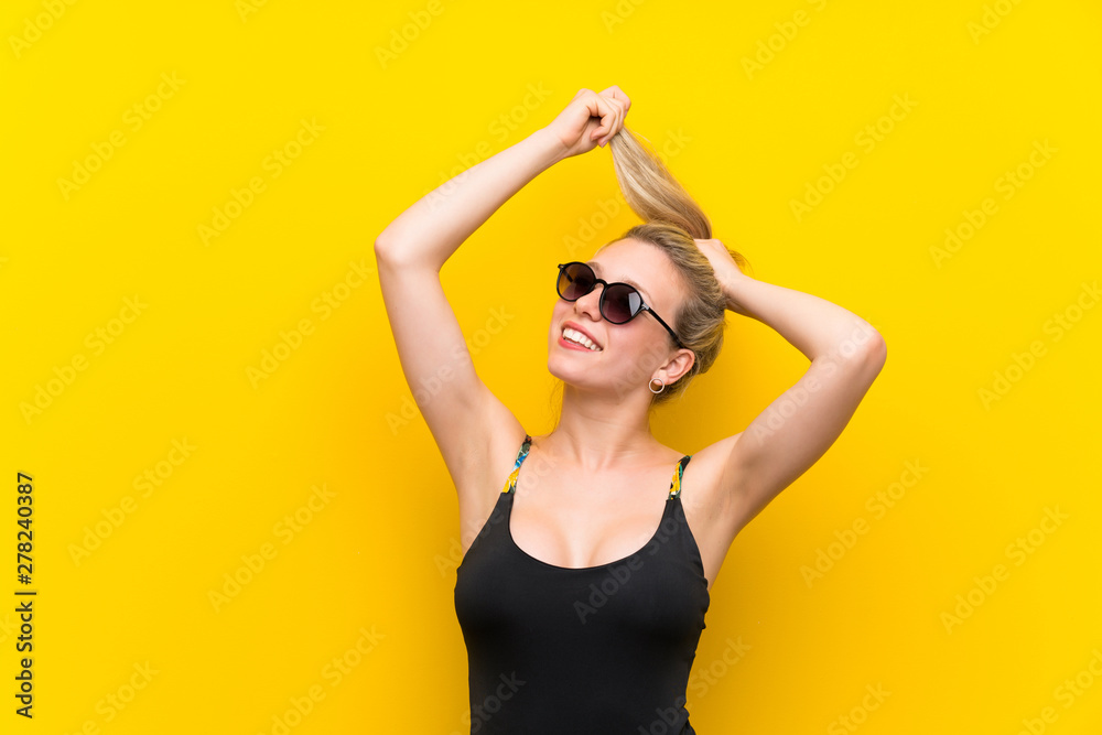 Young woman in swimsuit over yellow background Young woman in swimsuit over yellow background