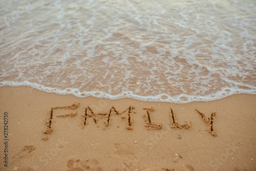 top view FAMILY lettering on the sand of a beach with wave and sunshine photo