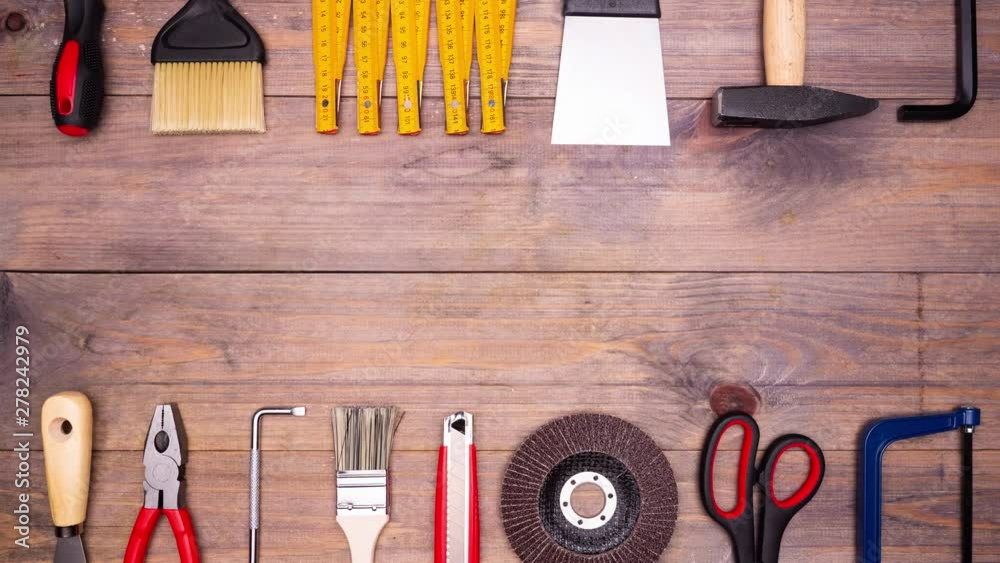 Different DIY tools moving on wooden background with copyspace. Top view. Stop motion animation. 4k.