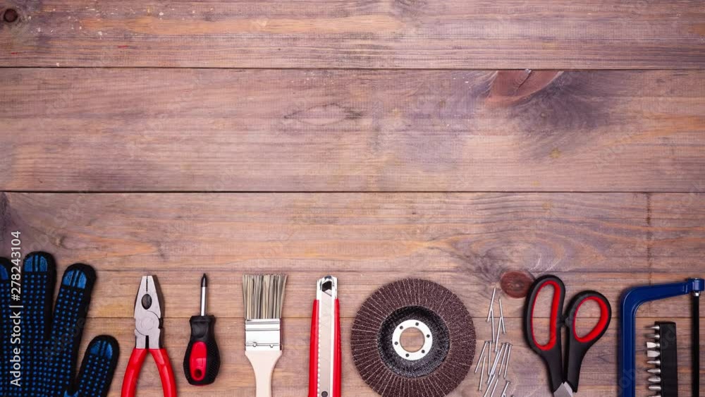 Different DIY tools moving on wooden background with copyspace. Top view. Stop motion animation. 4k.