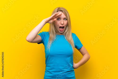 Young blonde woman over isolated yellow background has just realized something and has intending the solution
