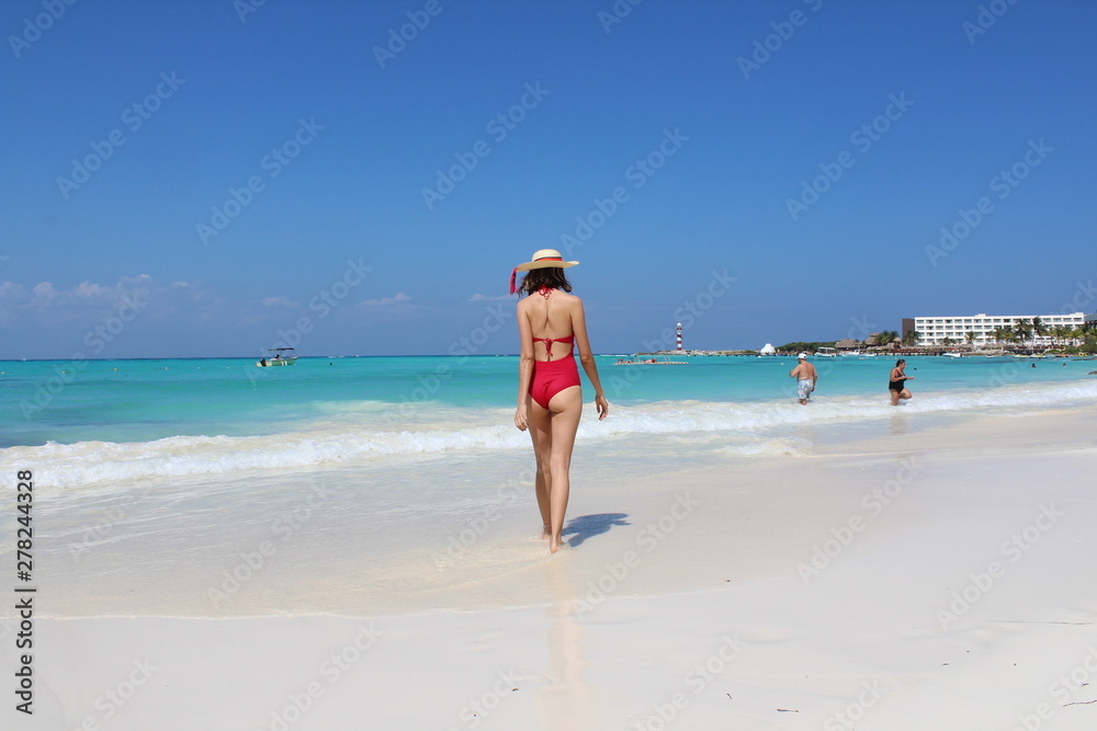 Mujer con traje de baño color rojo caminando en las playas de arena blanca  de cancun caribe mexicano Stock Photo | Adobe Stock