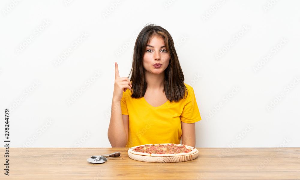 Caucasian girl with a pizza with surprise facial expression Caucasian girl with a pizza with surprise facial expression