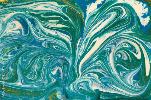 Liquid uneven blue and green marbling pattern with glare of light.
