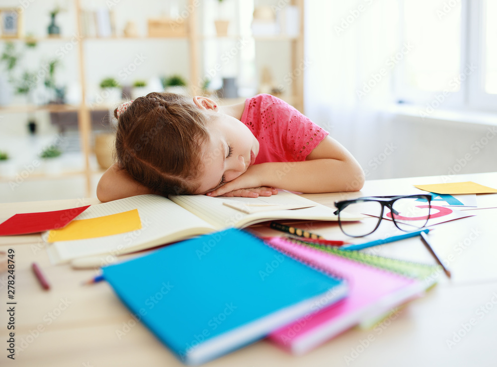 tired child girl fell asleep when she did her homework at home. tired child girl fell asleep when she did her homework at home.