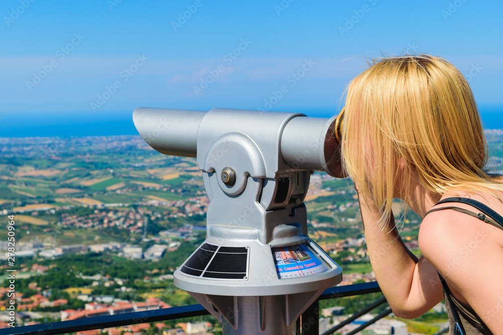 Woman watching through coin operated telescope