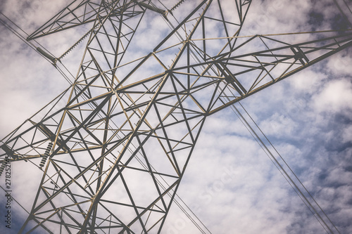 High Voltage Power Lines Against a Cloudy Blue Sky