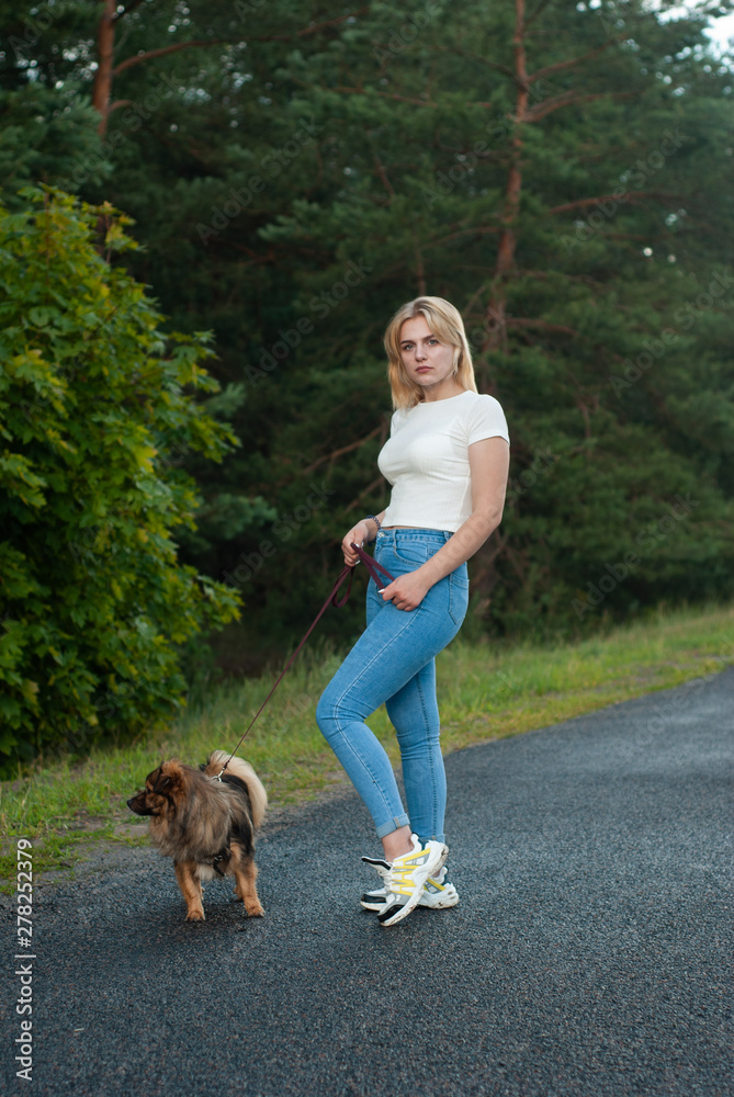 Portrait of a happy woman walking with her pet at leisure in a Park outside the city, blonde with dog posing, Portrait of a happy woman walking with her pet at leisure in a Park outside the city, blonde with dog posing,