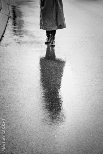 Person in Raincoat Reflected on Wet Street