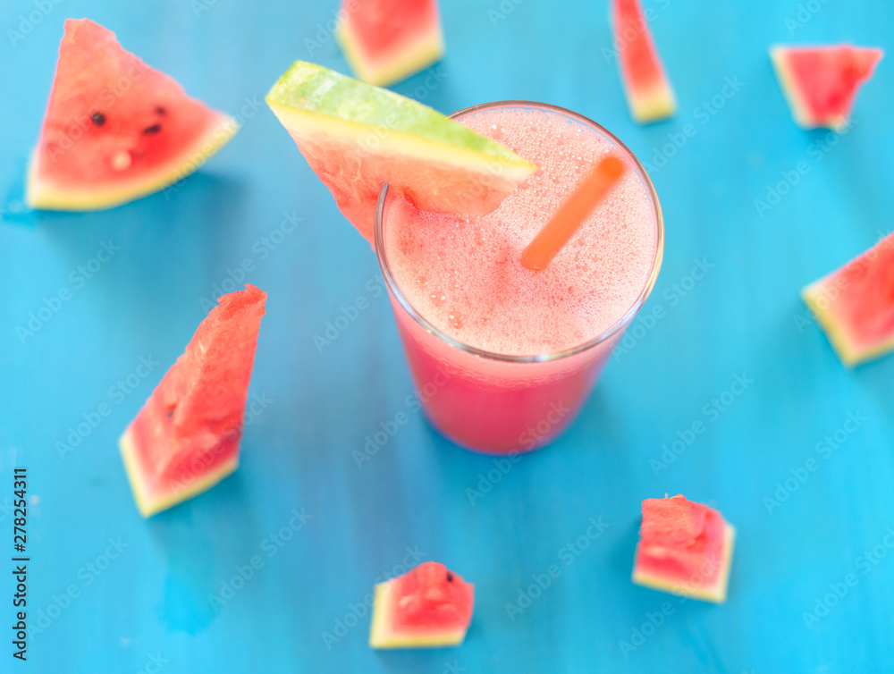 Glass of watermelon smoothie on a wooden blue table. Selective focus Glass of watermelon smoothie on a wooden blue table. Selective focus