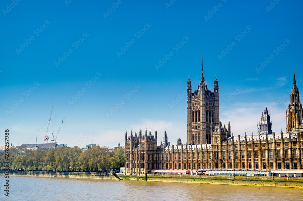 British Parliament along the River Thames on a sunny day in London, UK.