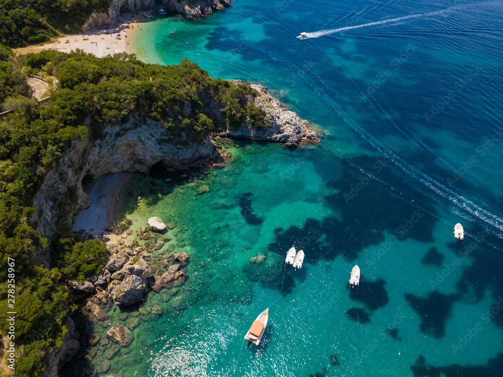 Boats near rocky coastline at Corfu island. Turquoise clear water. Aerial summer photo from drone. Greece.