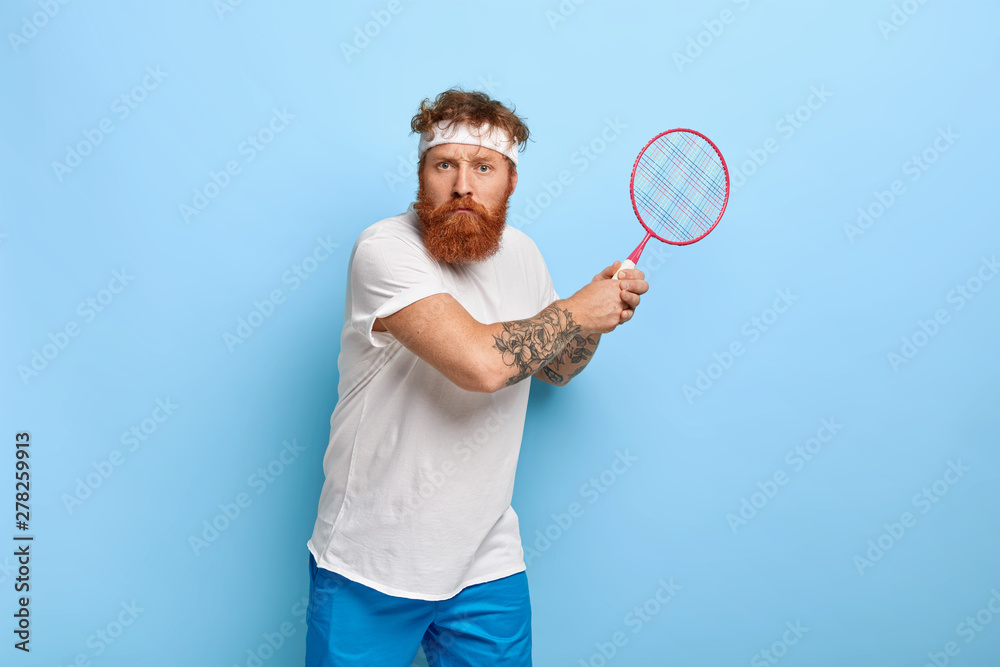 Determined serious tennis player beginner holds racket, ready to kick ball,  wears casual clothes, spends free time on court, prepares for sport  competition, has aim to win match. Reaching top Photos