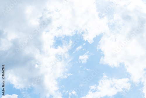 sun behind the clouds in blue sky in summer day