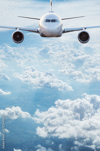 Fotografi Commercial airplane jetliner flying above dramatic clouds in beautiful light