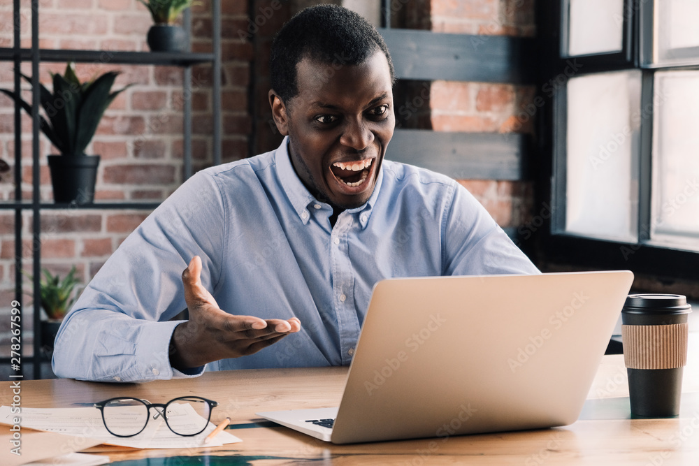 Angry office worker. Stressed african business man annoyed with computer pc  problem, frustrated about bad news Stock Photo | Adobe Stock