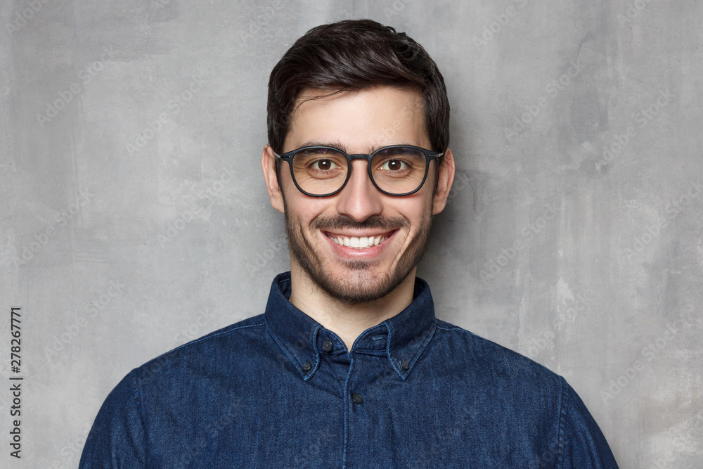 Obraz premium Headshot of guy wearing spectacles looking at camera with smile, isolated on background