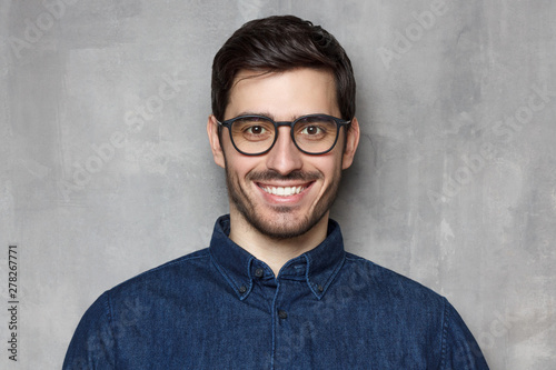 Headshot of guy wearing spectacles looking at camera with smile, isolated on background