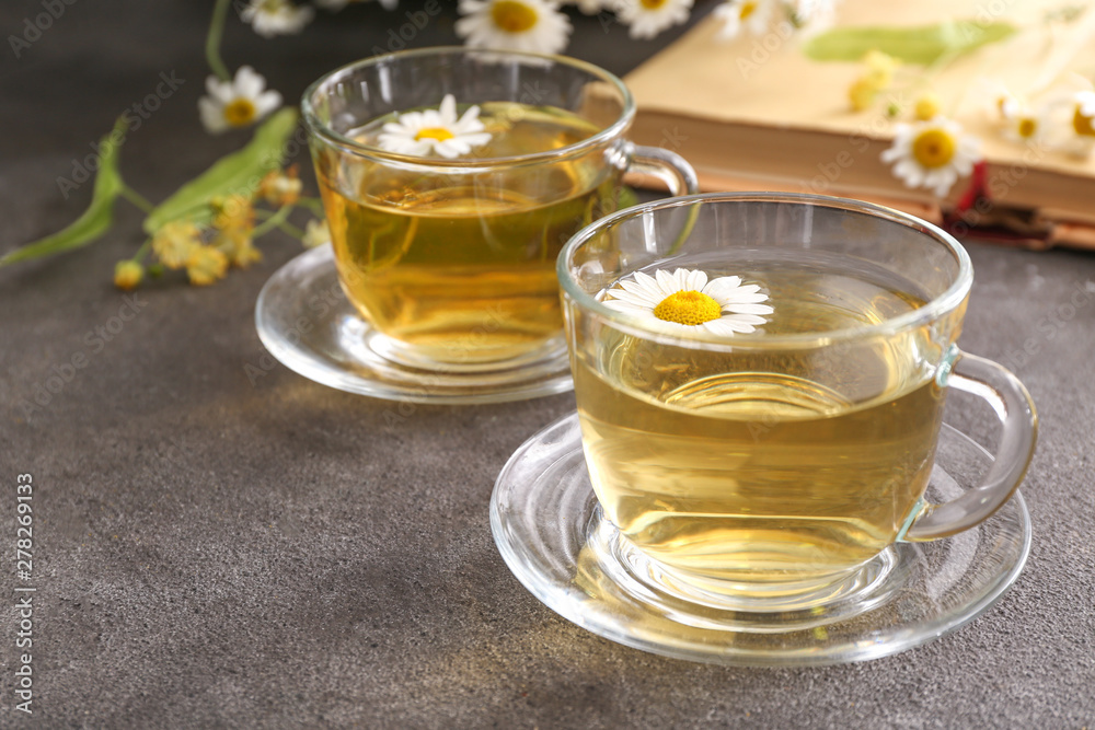 Cups of hot chamomile tea on grey table Cups of hot chamomile tea on grey table