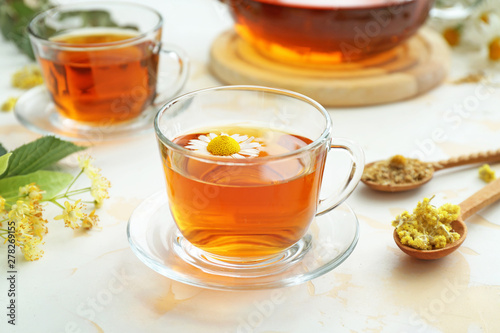 Cup of tasty chamomile tea on light table