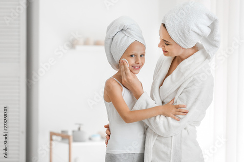 Mother applying lotion onto...