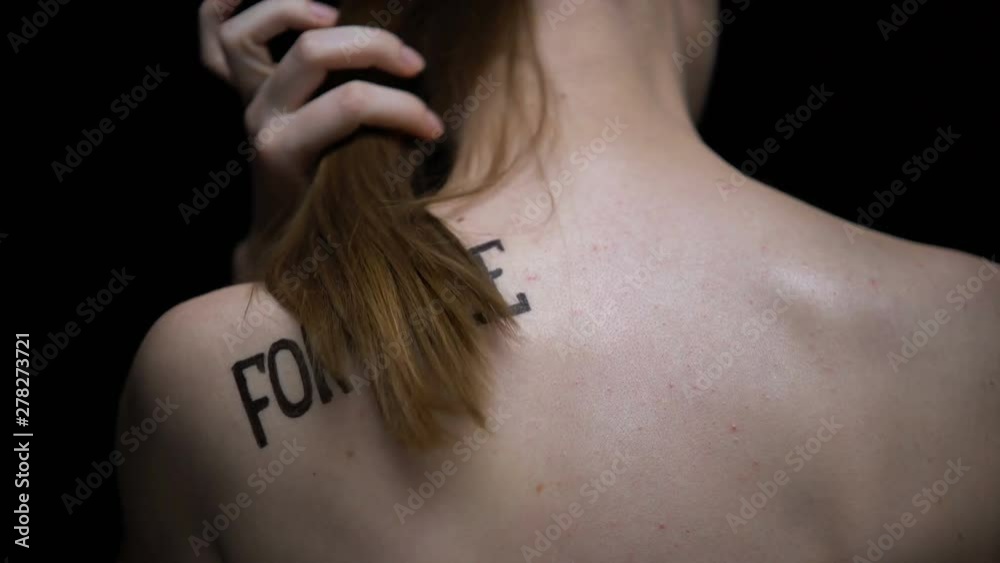 Trembling naked girl showing for sale phrase on shoulder, illegal sex industry Trembling naked girl showing for sale phrase on shoulder, illegal sex industry