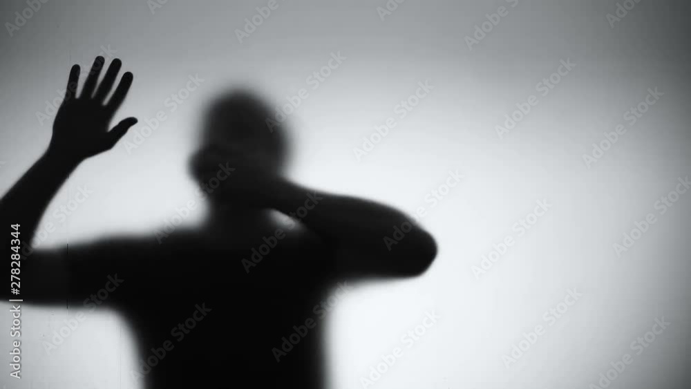 Silhouette of hardly breathing male falling down behind glass, asphyxia death