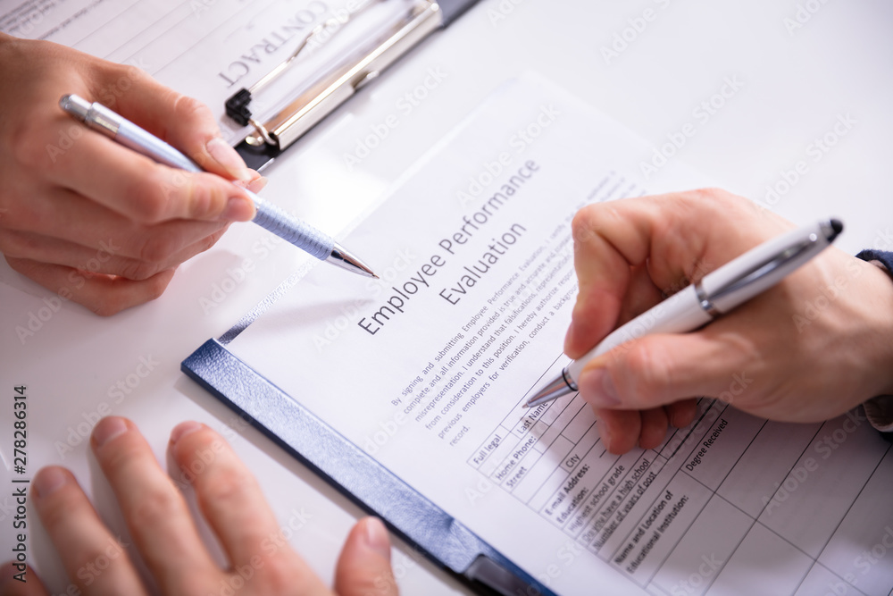 Person Filling Employee Performance Evaluation Form Person Filling Employee Performance Evaluation Form