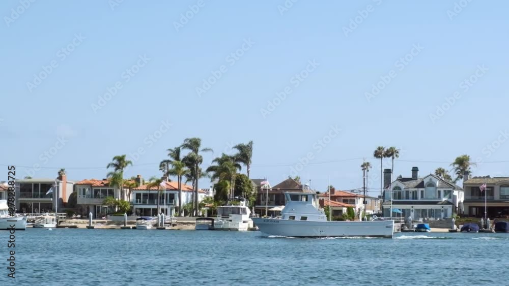 Slow Motion Shot, Boat Coasting Along Harbor among Luxurious Waterfront Homes