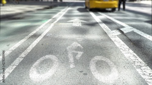 New York Bike lane close up, yellow cab dropping off a passenger in the distance