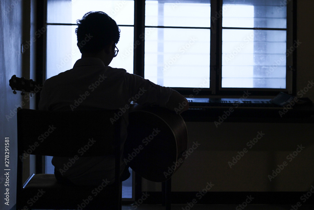 silhouette of musician in front of window silhouette of musician in front of window