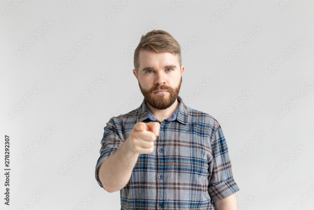 Angry man with beard, finger pointing towards the camera on a white background Angry man with beard, finger pointing towards the camera on a white background