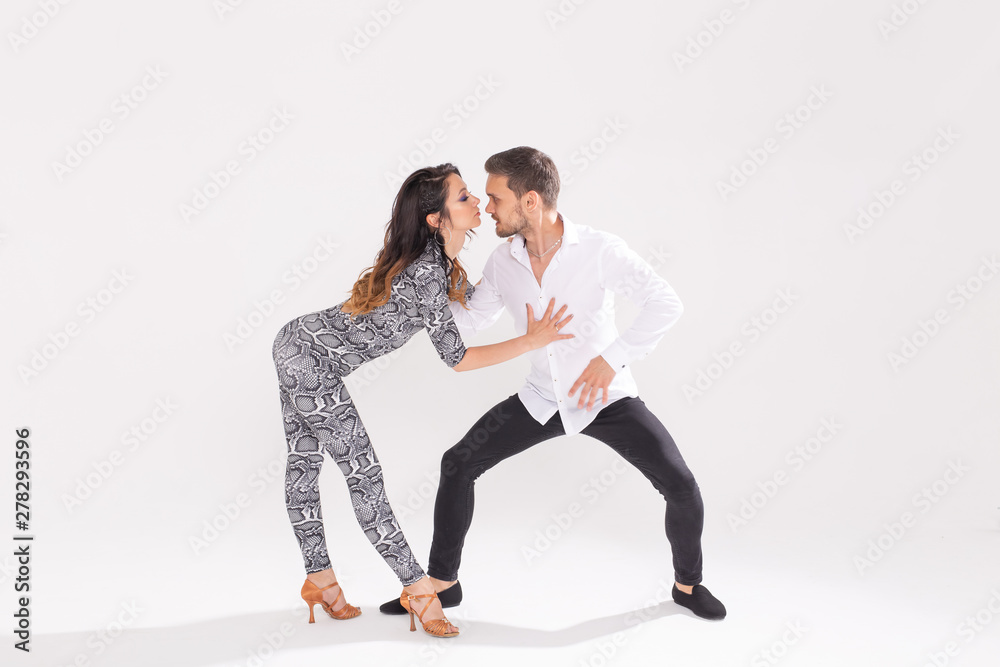 Fototapeta premium Social dance, bachata, kizomba, zouk, tango concept - Man hugs woman while dancing over white background with copy space