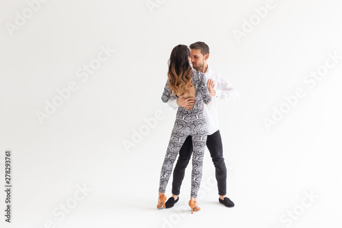 Skillful dancers performing in the white background with copy space. Sensual couple performing an artistic and emotional contemporary dance