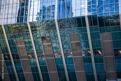 The Chicago river reflected on the glass paneling of the skyscraper at 150 North Riverside