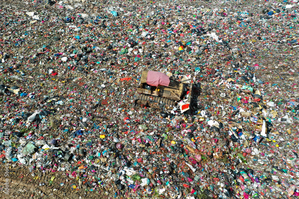 Plastic pollution crisis. Huge landfill garbage dump in Malaysia. Bulldozer flattens trash